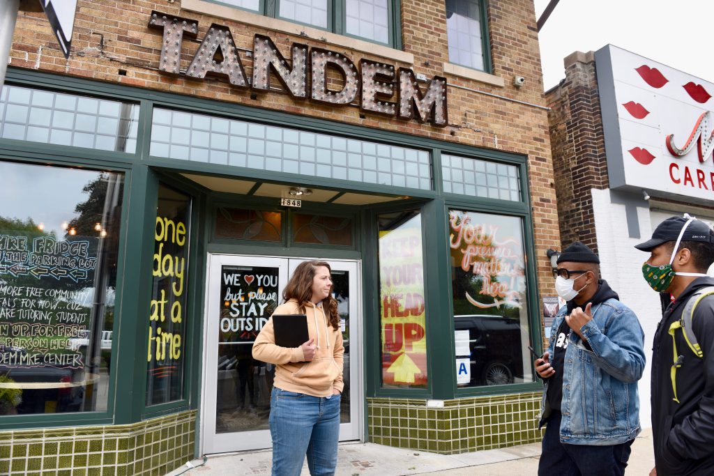 Caitlin Cullen, owner of The Tandem, has opened an outdoor area for students to get Wi-Fi and tutoring help. Here she takes orders for the restaurant’s free community meals program. Photo by Susan Vliet/NNS.