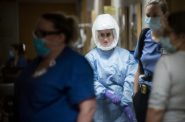 Nurses and doctors at University Hospital in Madison, Wis., walk through a hallway Tuesday, Nov. 17, 2020, in one of the hospital’s COVID-19 units. As coronavirus infections continue to surge statewide, patients are consistently filling all 28 of the unit’s beds — and Wisconsin’s top leaders continue to clash over how to address the pandemic. Angela Major / WPR