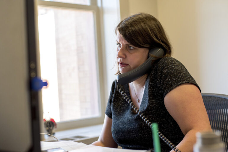 Claire Woodall-Vogg, executive director of the Milwaukee Election Commission, speaks on the phone from her office at City Hall during the partisan primary on Aug. 11, 2020. Woodall-Vogg favors legislation that would help clerks process absentee ballots before Election Day. Will Cioci / Wisconsin Watch