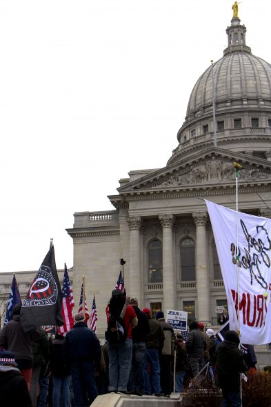 A QAnon flag flies in front of the Wisconsin State Capitol at the Dec. 7 pro-Trump election rally. Henry Redman/Wisconsin Examiner.
