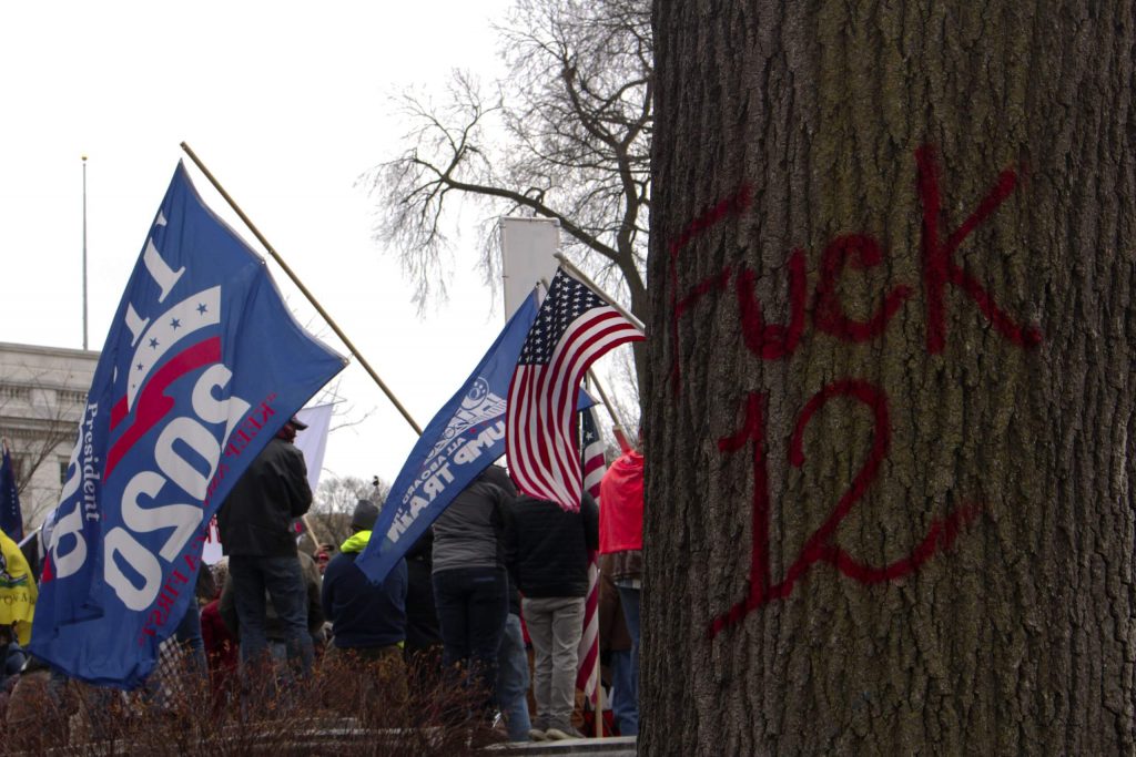 Evidence of Wisconsin’s year of political protest with pro-Trump protesters stand near anti-police graffiti from Black Lives Matter protests. Henry Redman/Wisconsin Examiner.