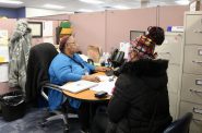 Shae Williams (left), a benefit specialist coordinator with the Social Development Commission, helps a client enroll in FoodShare. Photo provided by Kim Dawson-Brooks.