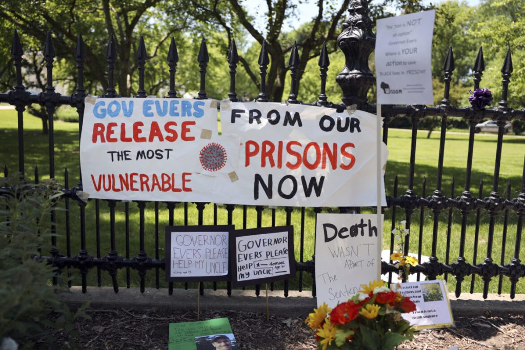 Signs and posters are left outside the Wisconsin governor’s mansion in Maple Bluff, Wis., on June 18, 2020, as part of a “Drive to Decarcerate” event. Those attending urged Gov. Tony Evers to release inmates from Wisconsin’s overcrowded prisons to slow the spread of COVID-19. Before the pandemic, Evers set a goal to cut the state’s prison population in half. But 23 state prisons still exceed their designed capacity. Photo by Coburn Dukehart / Wisconsin Watch