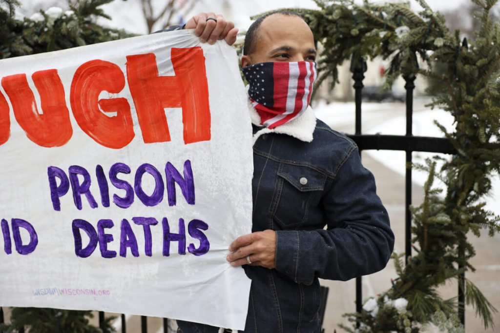 Ramiah Whiteside of Milwaukee holds a sign during a protest outside of the Wisconsin governor’s mansion in Maple Bluff, Wis., on Nov. 24, 2020. Event organizers sought to draw attention to the thousands of inmates and staff who have contracted COVID-19 in state prisons and called for Gov. Tony Evers to slow the spread of the disease by reducing overcrowding. Whiteside is prison outreach director for Milwaukee-based Ex-incarcerated People Organizing, which is part of Wisdom, a statewide faith-based prison advocacy group. Coburn Dukehart / Wisconsin Watch