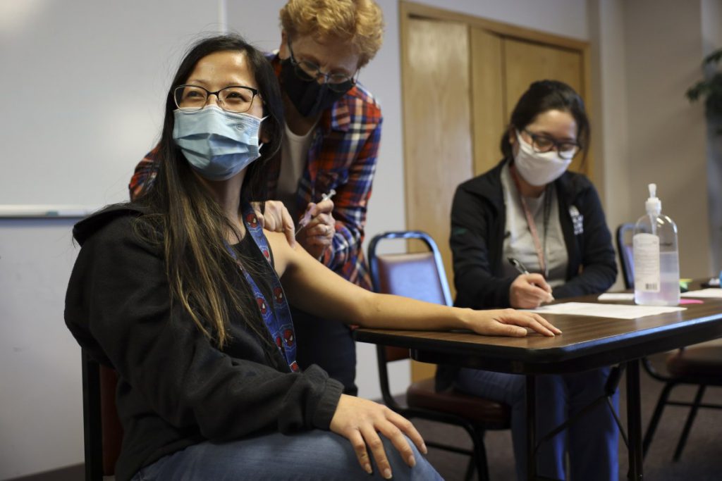 Lisa Xiong, a staff member at The Hmong Institute, gets her first dose of the Moderna COVID-19 vaccine at a clinic at Life Center in Madison, Wis. on March 9, 2021. “It wasn’t as bad as I thought,” she said after Laurel Losenegger, a volunteer nurse with the Benevolent Specialists Project, delivered the shot. Coburn Dukehart / Wisconsin Watch