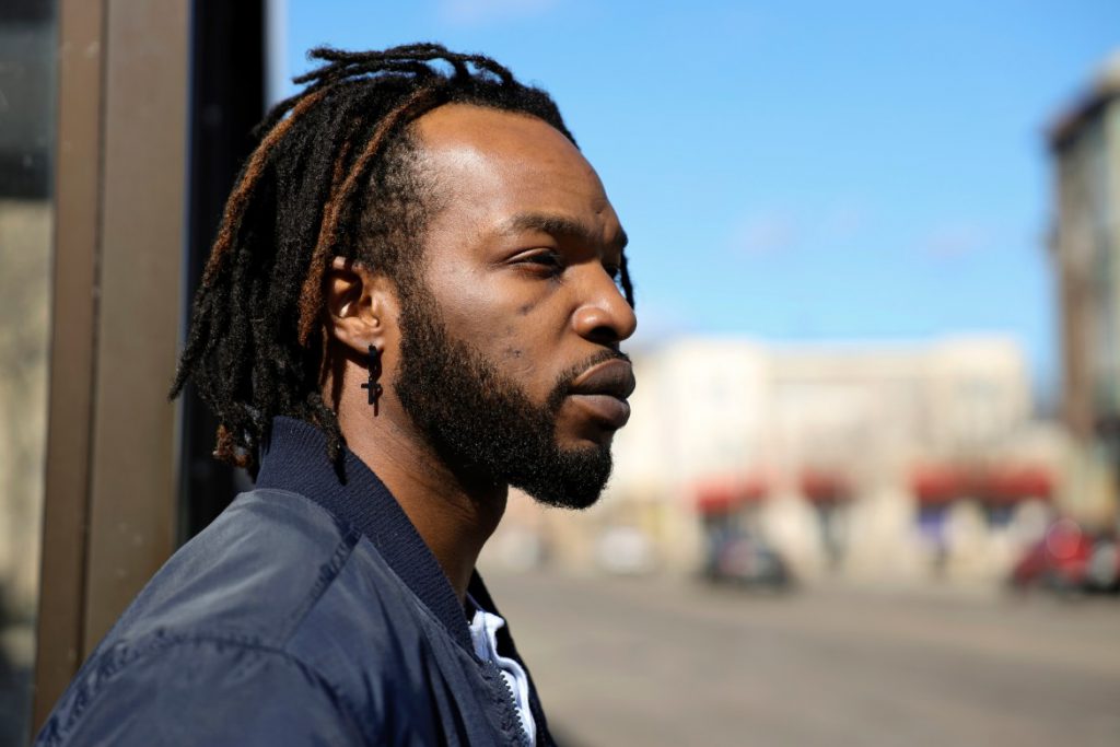 Jared Cain, a special education teacher and media entrepreneur, is seen near the intersection of West Center Street and North Dr. Martin Luther King Jr. Drive in Milwaukee on March 11, 2021. That's where he filmed and livestreamed a video showing protests against the police killing of George Floyd and property damage just after midnight on June 1, 2020. Police later cited the video as proof that he was in public after a 9 p.m. curfew kicked in — part of an emergency order aimed at curbing unrest. The ticket was later dismissed. "To me it's just systematic racism, and something has got to change," Cain said of Milwaukee's curfew enforcement. Credit: Coburn Dukehart / Wisconsin Watch