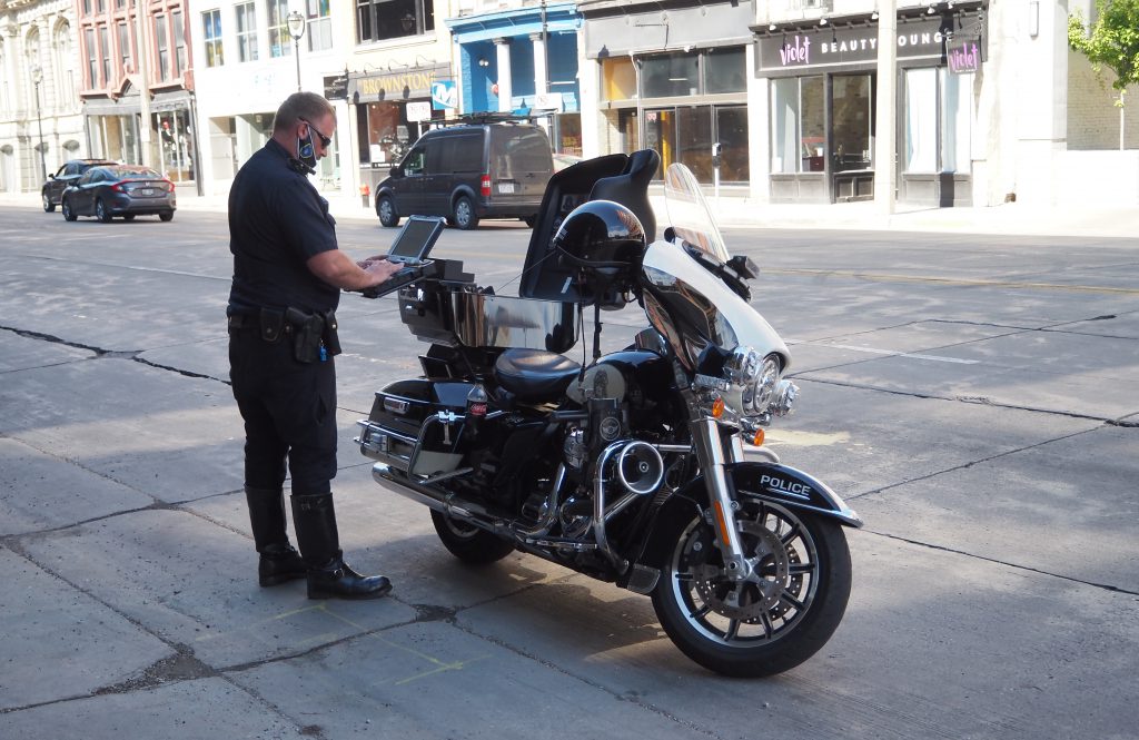 A Milwaukee Police Department officer enters a report into a laptop after a traffic stop. Photo by Jeramey Jannene.