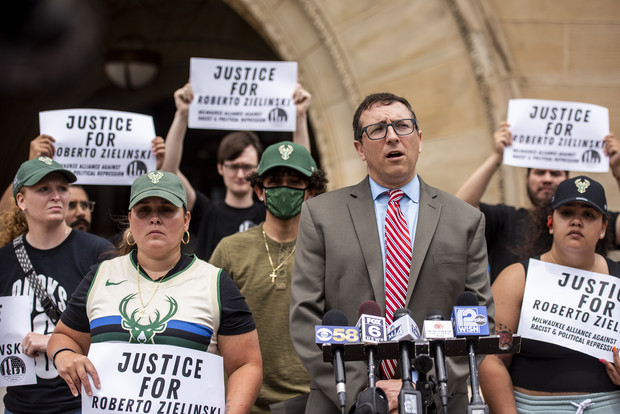 Attorney Russell Ainsworth speaks as Roberto Zielinski’s family members and supporters stand behind him holding signs Friday, July 16, 2021, in Milwaukee, Wis. Angela Major/WPR