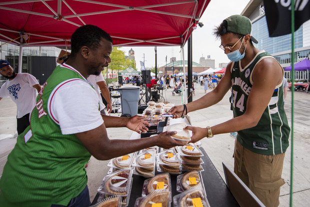 Quinnton Maney, right, an employee at Mecca Sports Bar and Grill near the Fiserv Forum, buys a pie from Mr. Dye's Pies on Wednesday, July 28, 2021, at the Deer District in Milwaukee, Wis. Angela Major/WPR