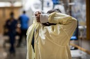 A healthcare worker ties a medical gown before caring for a patient who has COVID-19 on Tuesday, Nov. 17, 2020, at UW Hospital. Angela Major/WPR