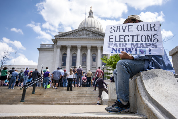 An attendee holds a sign at the Rally for Fair Maps on Monday, May 17, 2021, in Madison, Wis. Angela Major/WPR