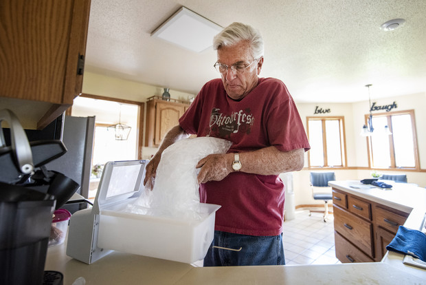 Dale Wetterling empties a bag of ice into a box before placing it in the freezer Tuesday, June 1, 2021, at his home in French Island, Wis. He and his wife, Mary, use ice from Kwik Trip due to PFAS contamination in their water. Angela Major/WPR