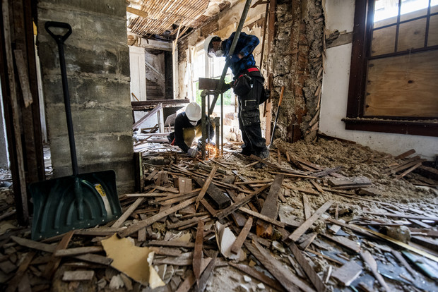Workers tear down parts of an old kitchen inside of a home before remodeling Thursday, Aug. 5, 2021, in Milwaukee, Wis. Angela Major/WPR