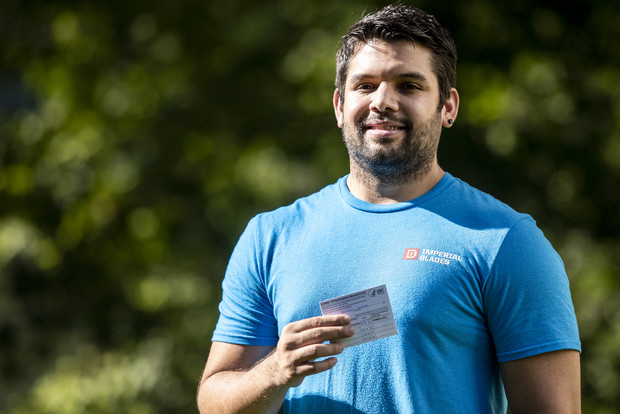 Miguel Marquez holds his COVID-19 vaccination record card Wednesday, June 30, 2021, near his home in Fitchburg, Wis. Angela Major/WPR