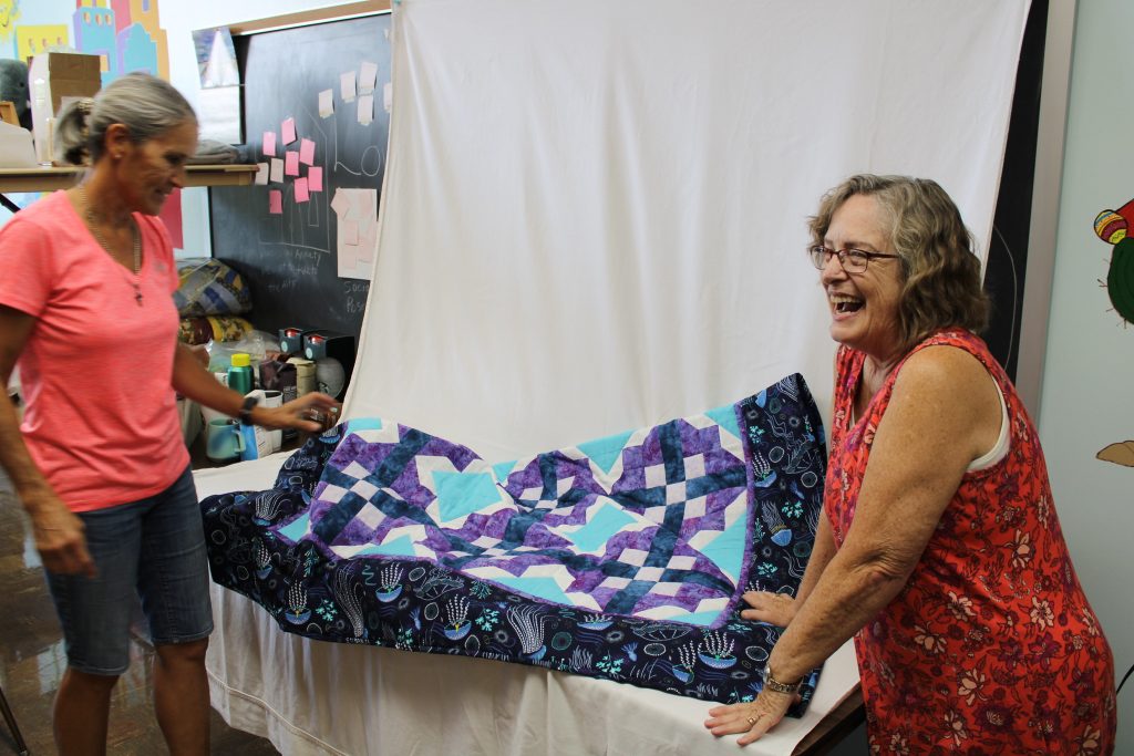 Gail Grenier Sweet (right) prepares a quilt for an upcoming online auction. She is the founder of the HOPE Single Mothers Network. Photo by Matt Martinez/NNS.