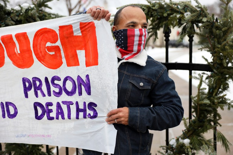 Ramiah Whiteside of Milwaukee holds a sign during a protest against the spread of COVID-19 in Wisconsin prisons outside of the governor’s mansion in Maple Bluff, Wis., on Nov. 24, 2020. Whiteside, who is formerly incarcerated, calls Wisconsin’s highest-in-the-nation rate of imprisoning Black residents “a slap in the face.” Whiteside works for Milwaukee-based EXPO, which advocates for formerly incarcerated people. Coburn Dukehart / Wisconsin Watch