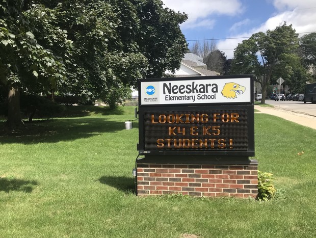 A sign outside Neeskara Elementary School in Milwaukee encourages kindergarten and pre-K students to enroll. The pandemic drove larger-than-usual enrollment declines, mostly in kindergarten and 4K students. Madeline Fox/WPR