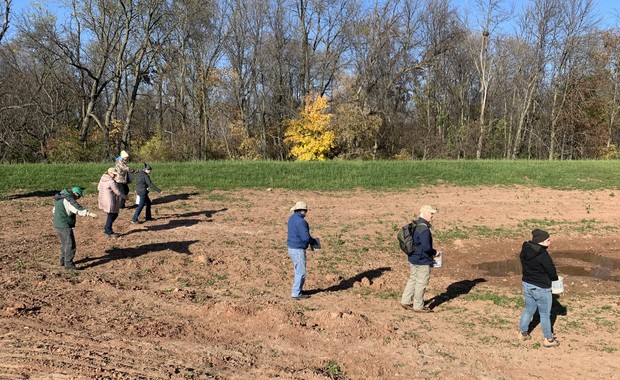 Volunteers hand sow wet meadow seeds on restored wetlands in Wequiock Creek Natural Area in Brown County on Nov. 4, 2021. Megan Hart/ Wisconsin Public Radio