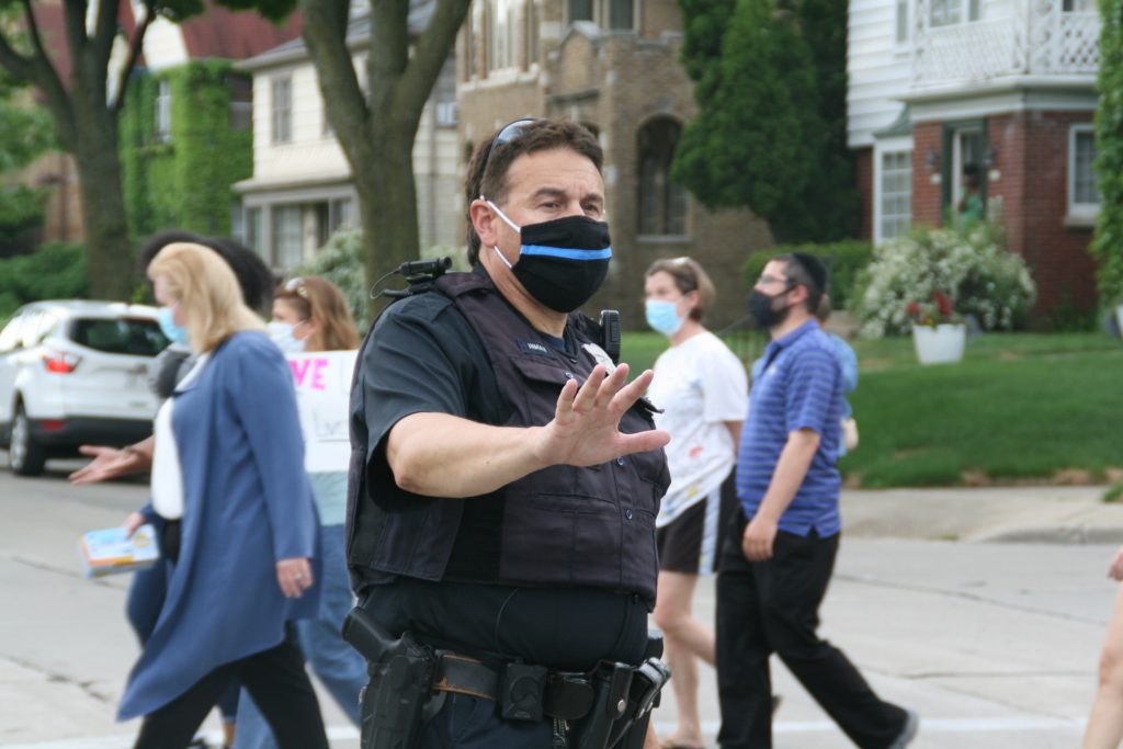 Milwaukee Police Department officer Gary Inman wears a thin blue line mask while directing traffic in June 2020. Photo by Jeramey Jannene.