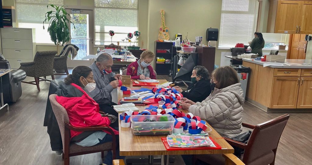 Participants at the Adult Day Center make decorations for Puerto Rican Discovery Day. Photo provided by United Community Center/NNS.