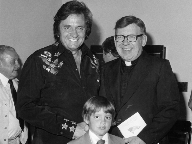 Cornell poses with Johnny Cash and an unknown boy. The priest organized concerts in Green Bay in the ’60s and ’70s and hosted the Johnny Cash Show and other well-known performers. Photo courtesy of the St. Norbert Abbey.