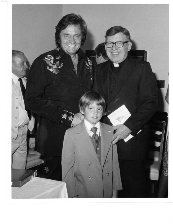Cornell poses with Johnny Cash and an unknown boy. The priest organized concerts in Green Bay in the ’60s and ’70s and hosted the Johnny Cash Show and other well-known performers. Photo courtesy of the St. Norbert Abbey.