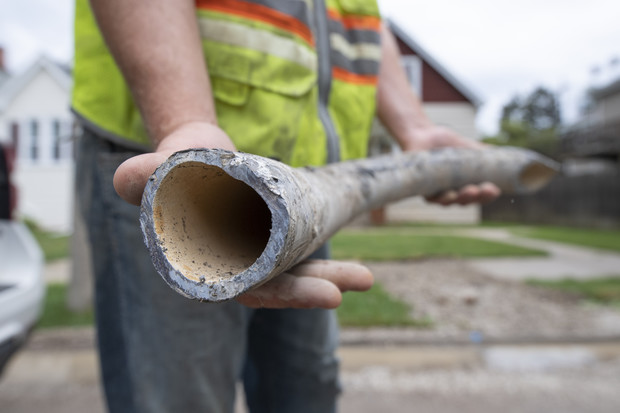 Tom Iglinski, an engineering technician with the city of Milwaukee, holds up a replaced lead service line on June 29, 2021. Since 2017, Milwaukee Water Works says it has swapped out 3,881 lead pipelines. Replacing the city’s remaining 70,000 lead service lines at that pace would take more than 70 years and cost hundreds of millions of dollars. Isaac Wasserman/Wisconsin Watch