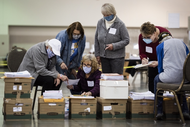Election officials gather around boxes of documents during a recount Monday, Nov. 23, 2020, at the Wisconsin Center in Milwaukee. Angela Major/WPR