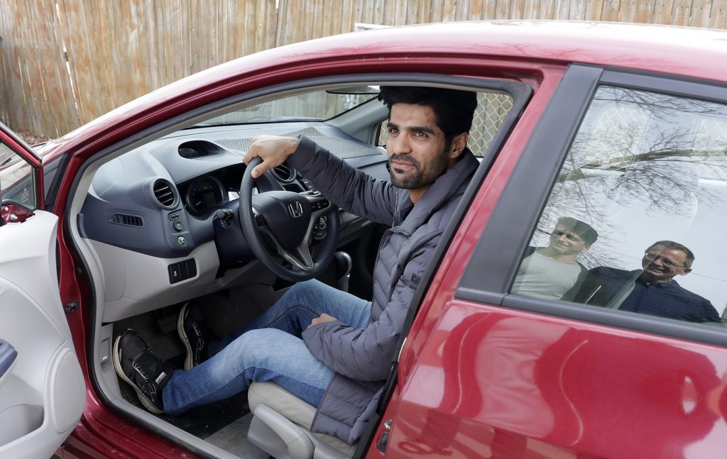 After receiving his driver’s license earlier in the year, Ahmad Samim Samimi tests out a vehicle for sale while talking to Fayaz Nabizada and Mike Ruminski on April 10, 2022, in Allouez, Wis. Transportation “is a critical need for people trying to become self-sufficient,” says Ruminski, who has helped local Afghan evacuees obtain driver’s licenses, enroll in English classes and connect with job specialists. (Sarah Kloepping/USA TODAY NETWORK-Wisconsin)