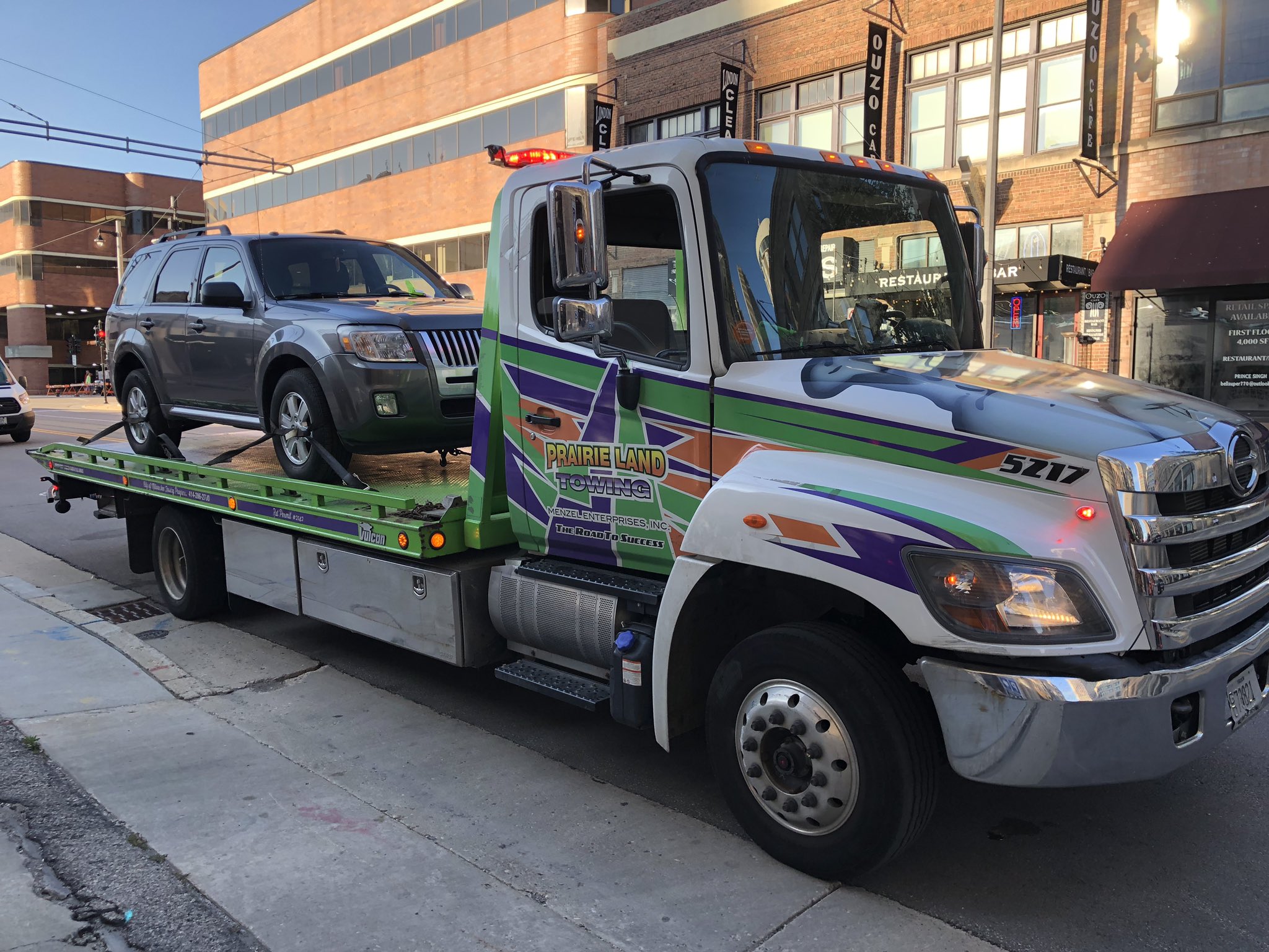 A tow truck hauls away a vehicle on N. Milwaukee St. in 2019. Photo by Jeramey Jannene.