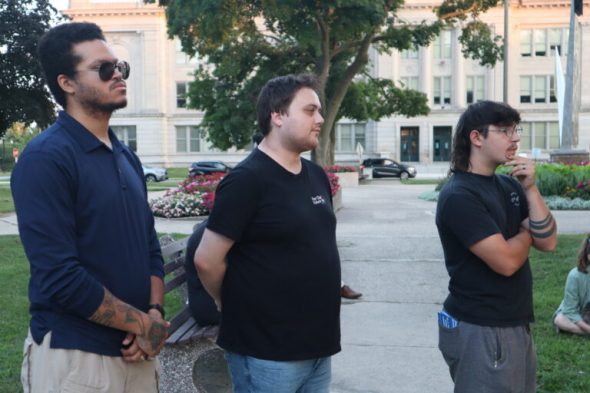Kyle Johnson of BLOC (left) and Kyle Flood of For Our Future Wisconsin (center) stand with other community members in Civic Park, two years after the Kenosha uprising. Photo by Isiah Holmes/Wisconsin Examiner.
