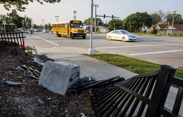 Vehicles drive on Sept. 14, 2022, past a fence that was damaged during a crash on West Fond du Lac Avenue and West Congress Street in Milwaukee. West Fond du Lac Avenue, which doubles as State Highway 145, runs northwest from downtown Milwaukee and includes several of the city’s most crash-prone intersections. (Angela Major / WPR)