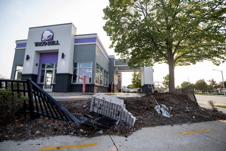 A Taco Bell at the corner of Milwaukee’s West Fond du Lac Avenue and West Congress Street is surrounded by a fence that was damaged during a fatal crash. West Fond du Lac Avenue doubles as State Highway 145 — a “connecting highway” that runs through the city. In 2017, 18 of Milwaukee’s 25 most crash-prone intersections sat on or near connecting highways. Sixteen of those high-crash intersections were on or near Fond du Lac Avenue or Capitol Drive, according to a report by the city Department of Public Works and Police Department. Photo taken on Sept. 14, 2022. (Angela Major / WPR)
