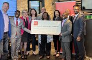 Wells Fargo employees, led by Gigi Dixon (center), present Milwaukee leaders with a check for $7.5 million. Those pictured include LISC director Theodore Lipscomb Sr. (far left), County Executive David Crowley (holding check), CDA CAO Teig Whaley-Smith (behind Dixon, center) and Mayor Cavalier Johnson (holding check, right). Photo by Jeramey Jannene.
