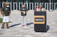 Mayor Cavalier Johnson speaks at an early voting press conference outside Fiserv Forum while Bango, Peter Feigin and Claire Woodall-Vogg look on. Photo by Jeramey Jannene.