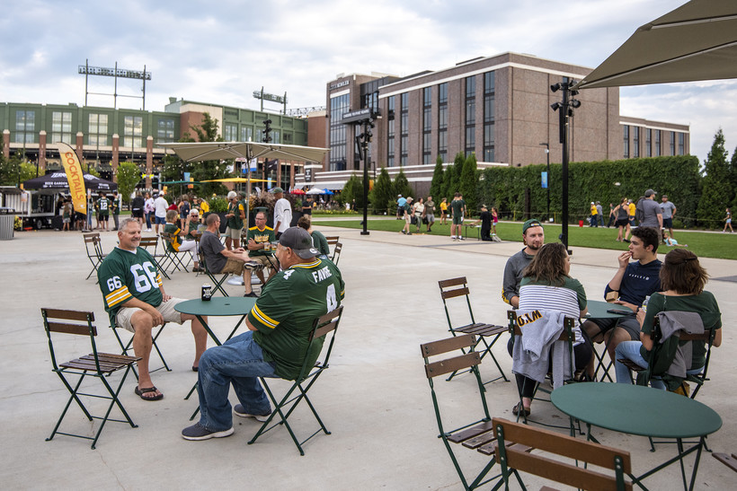 Packers fans sit in the Titletown District in Ashwaubenon before a preseason home game Friday, Aug. 19, 2022. Angela Major/WPR