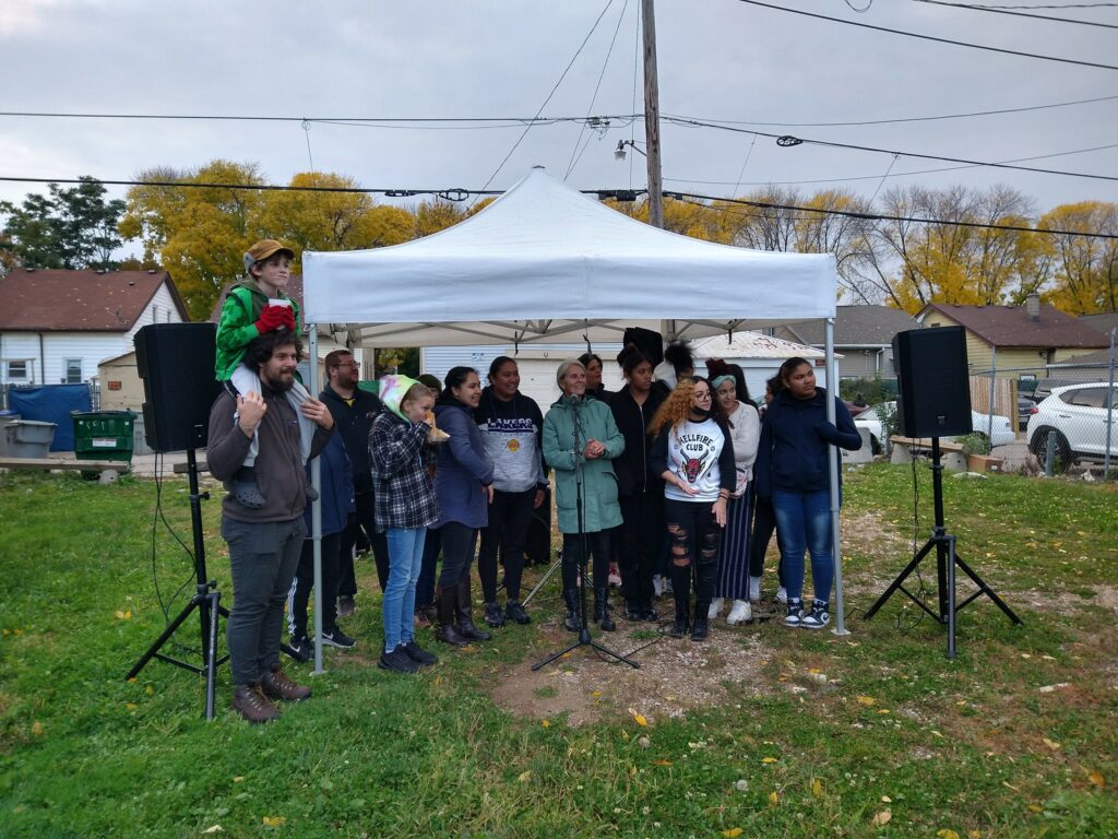 Residents gather to celebrate the installation of new bollards on Cesar Chavez Drive. The bollards memorialize lessons learned during the pandemic and the First Nations and immigrant groups that moved to Milwaukee before 1920. (Photo by Sam Woods)