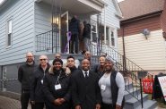 Mayor Cavalier Johnson poses with the board of the Milwaukee Community Land Trust outside the nonprofit's first home, 2025 S. 25th St. Photo by Jeramey Jannene.