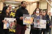 Faith and immigrant rights groups gather in city hall to bring attention to Title 42. Several held pictures of migrant refugees at a camp in Mexico. (Photo | Isiah Holmes)