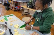 A student in FoodRight’s Youth Chef Academy program slices apples for a healthy recipe made at school. Photo provided by FoodRight.