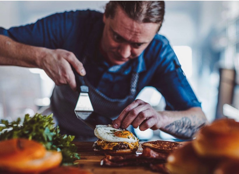 Mill City Public House head chef James Dudley prepares a brunch burger. The Appleton restaurant is one of many new businesses created since the beginning of the COVID-19 pandemic. Those businesses now face inflation and an ongoing labor shortage. Photo Courtesy of Mill City Public House