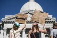 Protesters hold signs while protesting the U.S. Supreme Court’s draft ruling on Roe vs. Wade on Saturday, May 14, 2022, at the Wisconsin state Capitol in Madison, Wis. Angela Major/WPR
