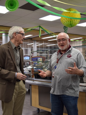 Gov. Tony Evers talks to Michael Gasper, director of nutrition services for School District of Holmen, about participation in school meals during a visit to Holmen High School on Monday, March 13, 2022. Hope Kirwan/WPR