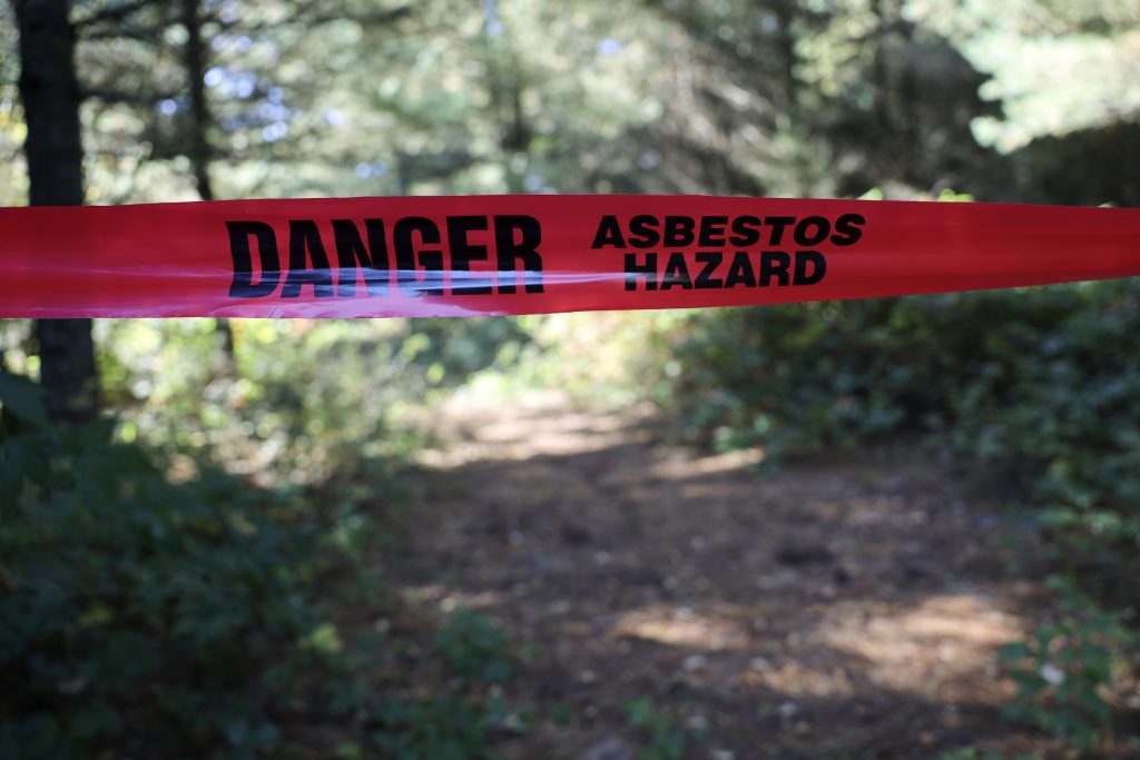Caution tape on Zach Skrede’s property in the Town of Easton, in Adams County, Wis., is seen on Oct. 10, 2022 warning about the presence of asbestos. Skrede purchased his house and the surrounding land in 2019, and did not know the asbestos was on the property. Republican and Democratic lawmakers in Wisconsin have renewed legislative efforts to help “innocent purchasers” pay to clean up contamination they did not cause. (Coburn Dukehart / Wisconsin Watch)