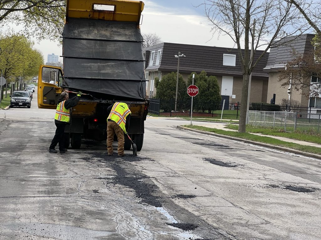 A Department of Public Works crew fills potholes by W. Juneau Ave. and N. 20th St. Photo by Jeramey Jannene.