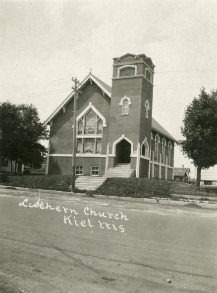 In 2020, Rev. Brett Naumann, pastor of Trinity Lutheran Church in Kiel, emailed the state Department of Public Instruction with questions related to the treatment of gay and transgender students if his school joined the voucher program. A postcard of Trinity Lutheran Church shortly after it was completed in 1918. (Image courtesy of the Heritage Collection at Kiel Public Library)