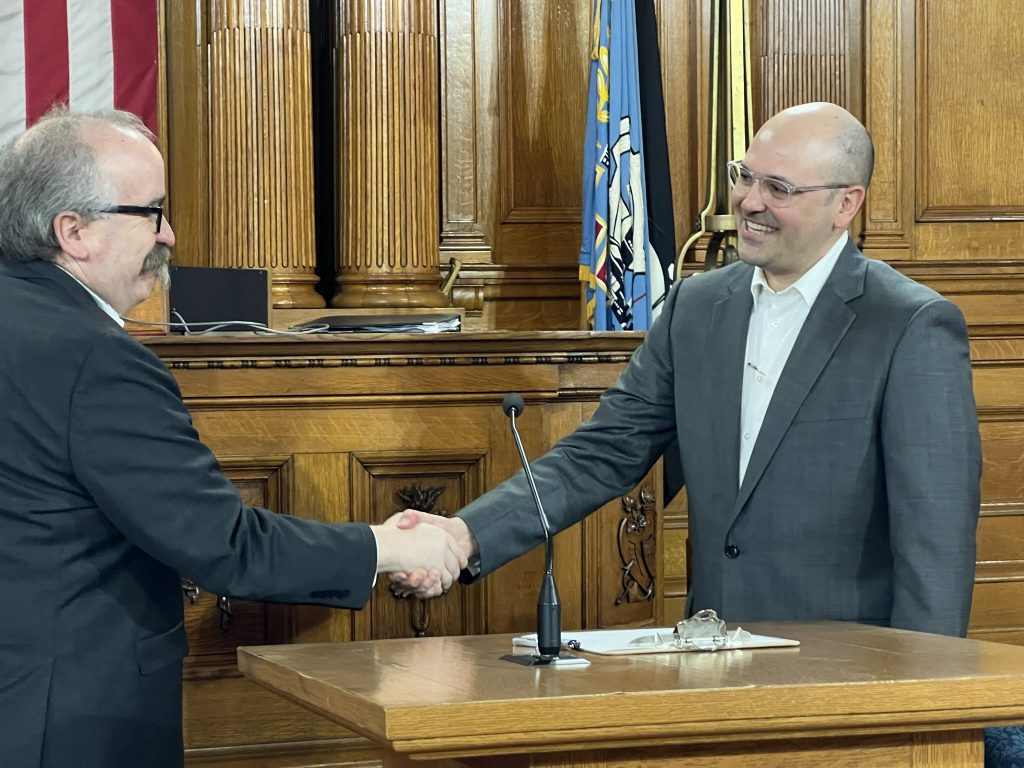 City Clerk Jim Owczarski (left) shakes Health Commissioner Michael Totoraitis' hand after administering the oath of office. Photo by Jeramey Jannene.