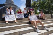 Protesters hold signs in response to the Supreme Court overturning Roe vs. Wade on Friday, June 24, 2022, outside of the Wisconsin state Capitol in Madison, Wis. Angela Major/WPR