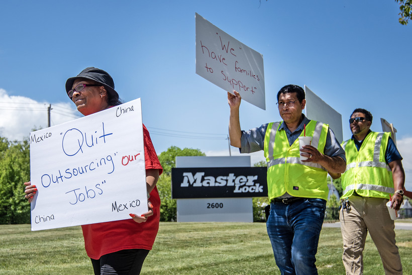 Workers hold signs as they march Wednesday, May 31, 2023, outside of the Master Lock plant in Milwaukee, Wis. Angela Major/WPR