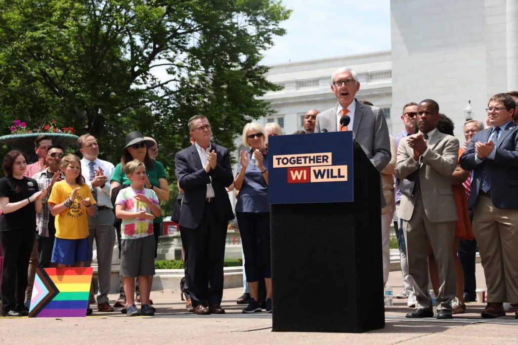 Gov. Tony Evers speaks at a Pride flag raising ceremony outside the Wisconsin State Capitol building on June 1, 2023, to celebrate the beginning of Pride month. Evers signed an executive order in 2021 directing Wisconsin state agencies to make forms and documents gender neutral. (Drake White-Bergey / Wisconsin Watch)